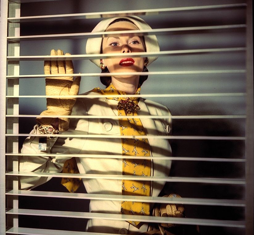 venetian-blinds A model peeks through Venetian blinds.