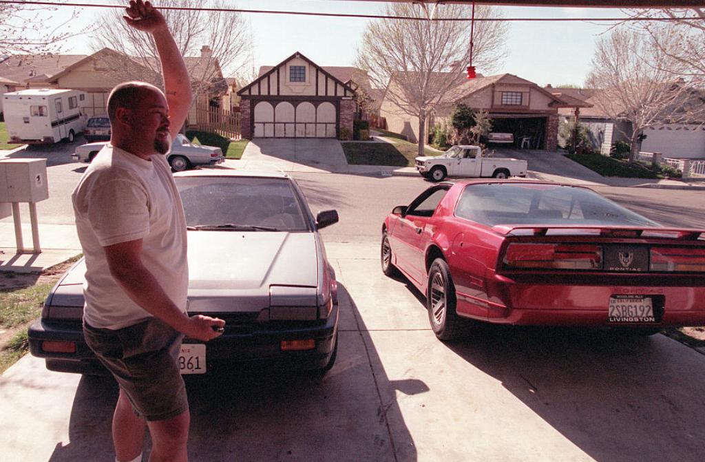 open-garage A man stands before his opened garage.
