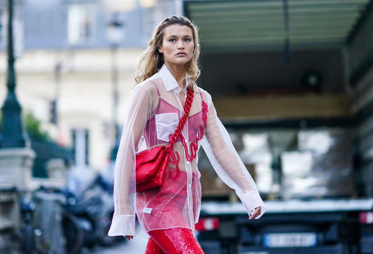 sheer white shirt - 1202271355 A woman wears pink under a sheer white shirt.