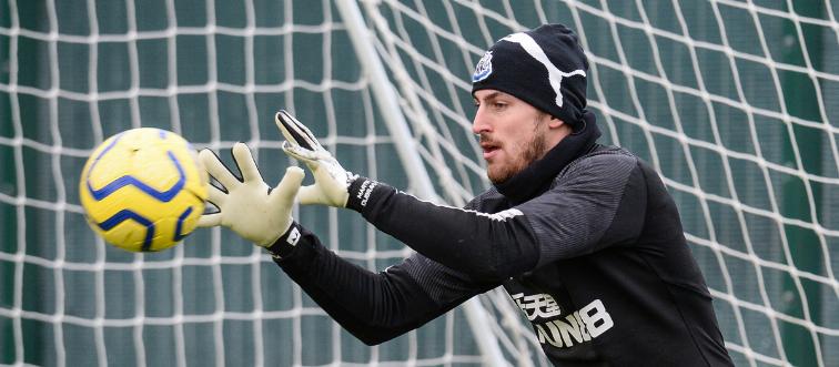 A goalkeeper catches a soccer ball.