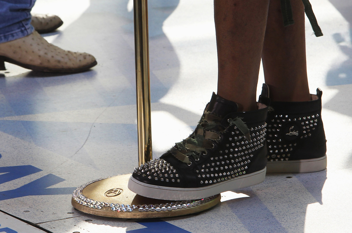 bedazelled shoes - 147940740 A person with bedazzled shoes steps on a microphone stand.
