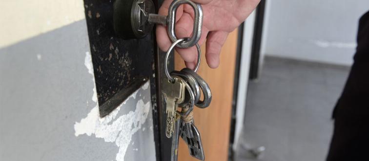 A man opens a door with a key.