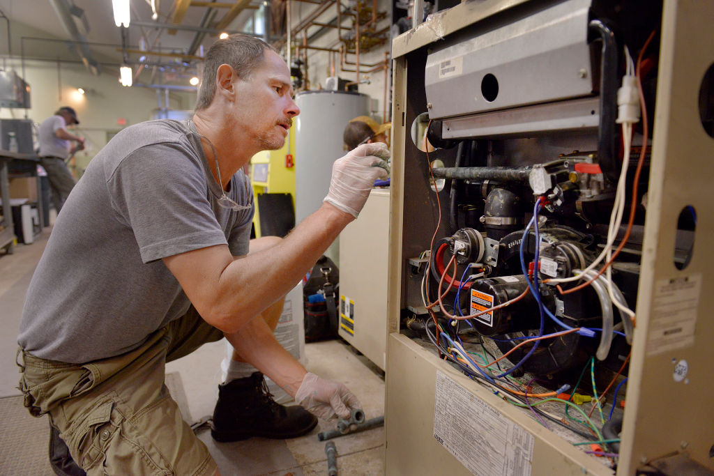 HVAC check Steven Sweet, from Windham, works on a gas furnace