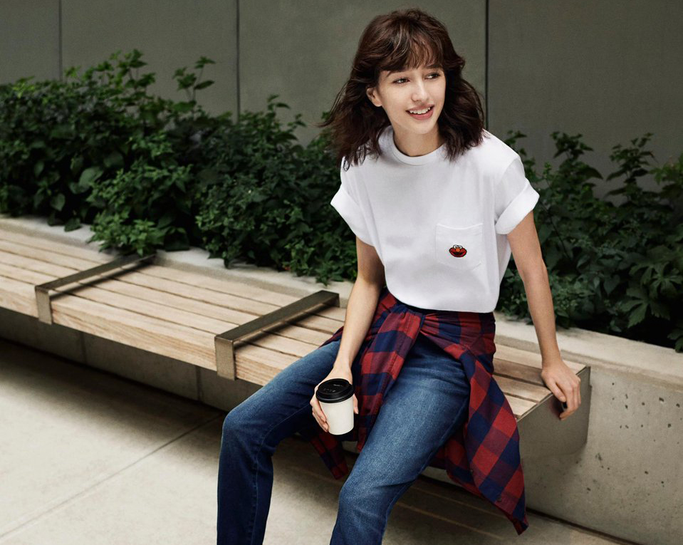 flannel around waist A woman with a flannel tied around her waist drinks coffee on a bench.