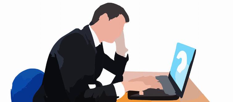 A man ponders as he browses his computer.