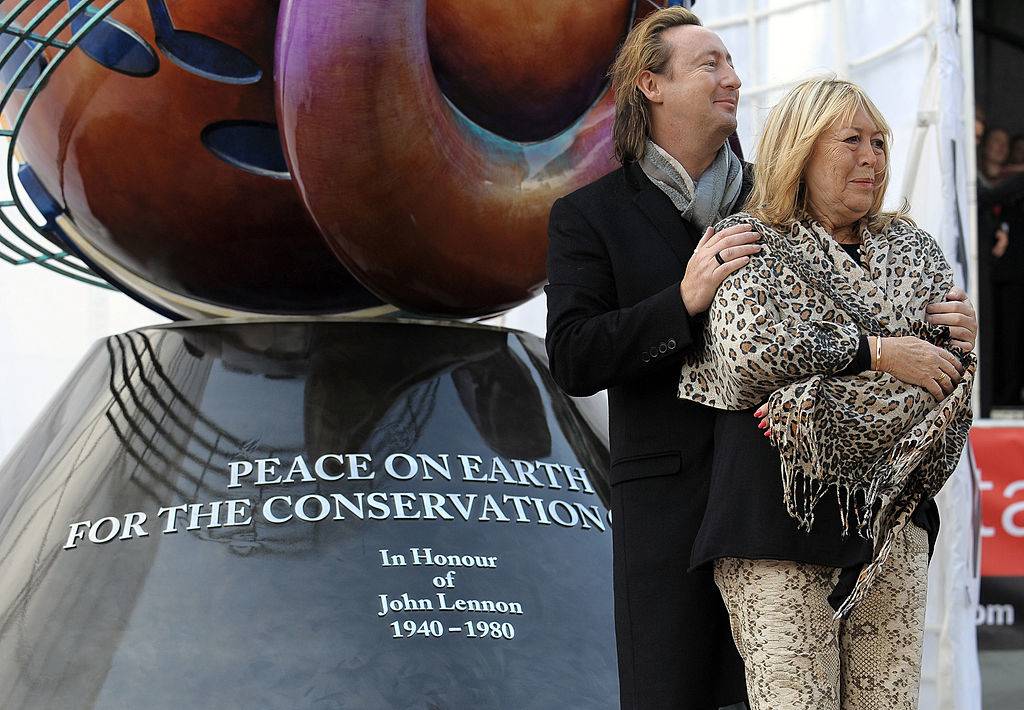 Julian puts his arms around his mother Cynthia as they pose before the john lennon monument in liverpool.