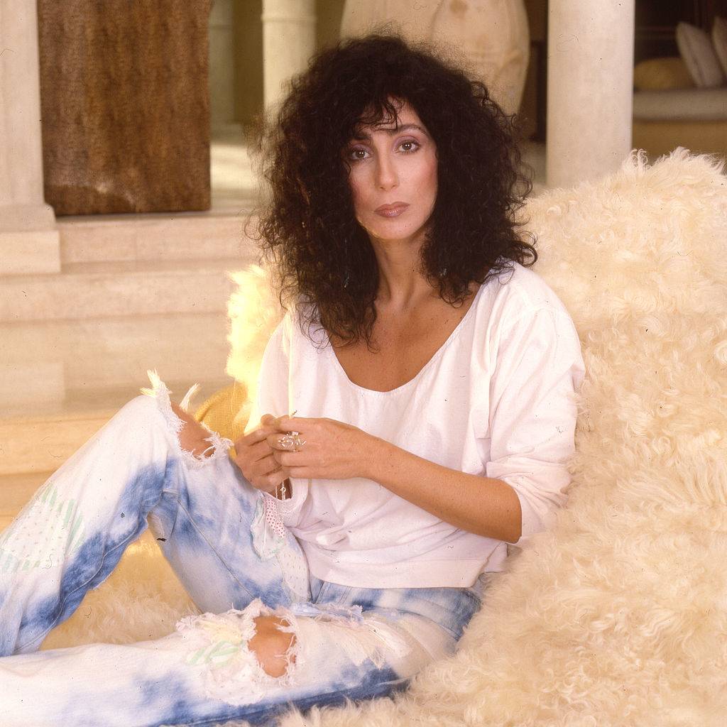 Cher relaxes on a shag chair.