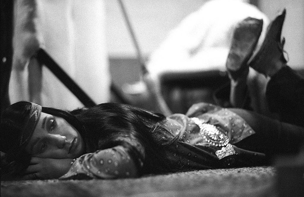 Cher lies on her stomach looking bored.