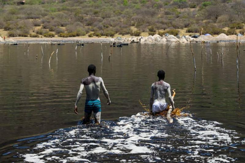 Men walking into lake 