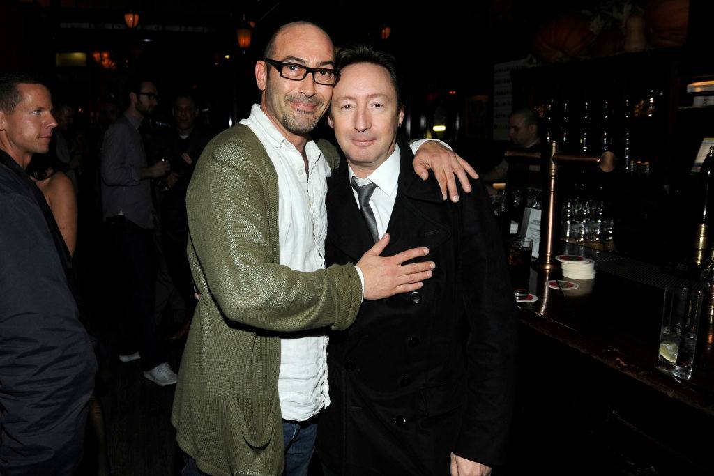 A man puts both arms around Julian.