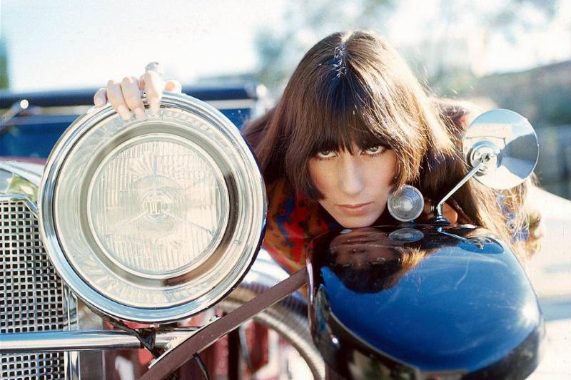 Cher models near a car headlight.