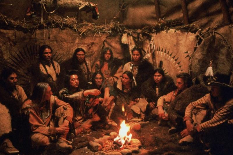 Actors sitting around a fire