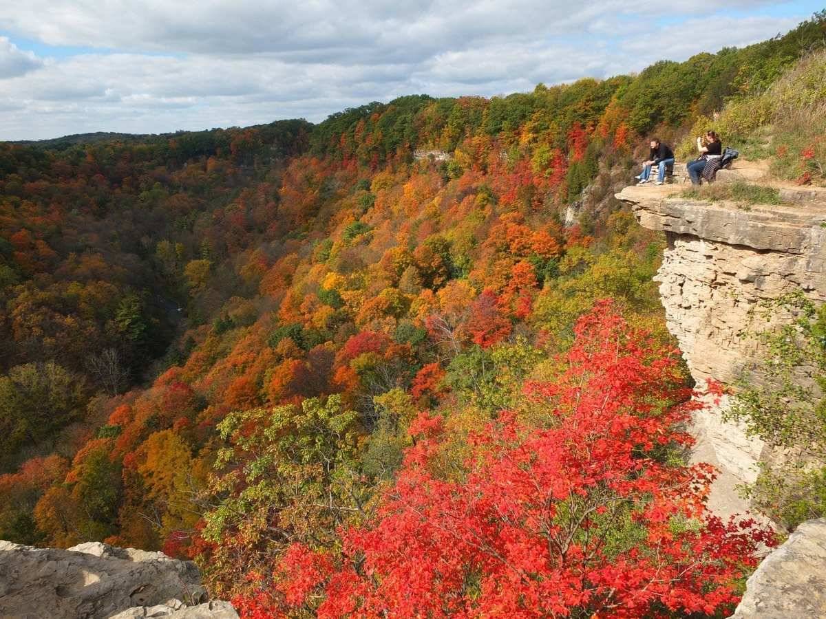 A woman takes a picture of a man while they both are at Dundas Peak.