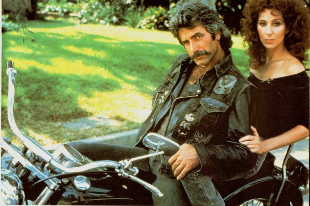 Sam Elliot and Cher is on a motorcycle for a publicity still for the movie Mask.