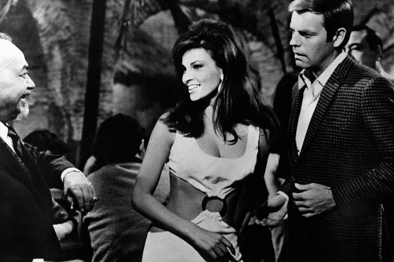WAmerican actress Raquel Welch (Jo Raquel Tejada) smiling to American actor Robert Wagner in the film The Biggest Bundle of Them All. American actor Godfrey Cambridge is watching them. 1968