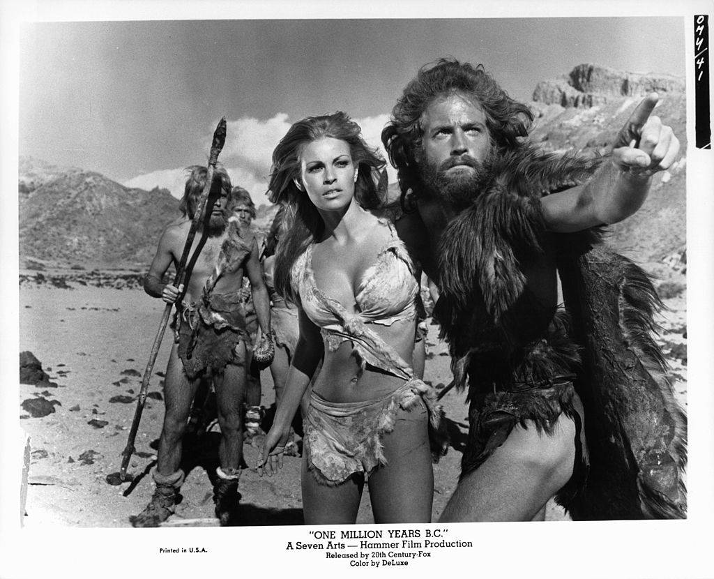 Raquel Welch looking in the direction that John Richardson is pointing to in a scene from the film 'One Million Years B.C.', 1966.