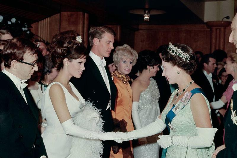 14th March 1966: American actress Raquel Welch shaking hands with Queen Elizabeth II of Great Britain at a Royal Film performance. Next in line is the American comedian, writer and director, Woody Allen.