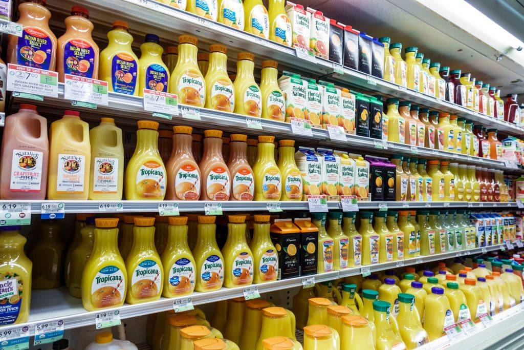 orange juice lined up in a grocery store