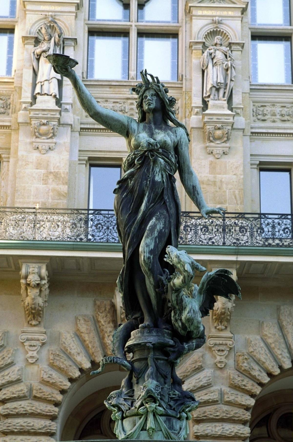 A statue of the Greek goddess Hygieia stands on top of a fountain. 