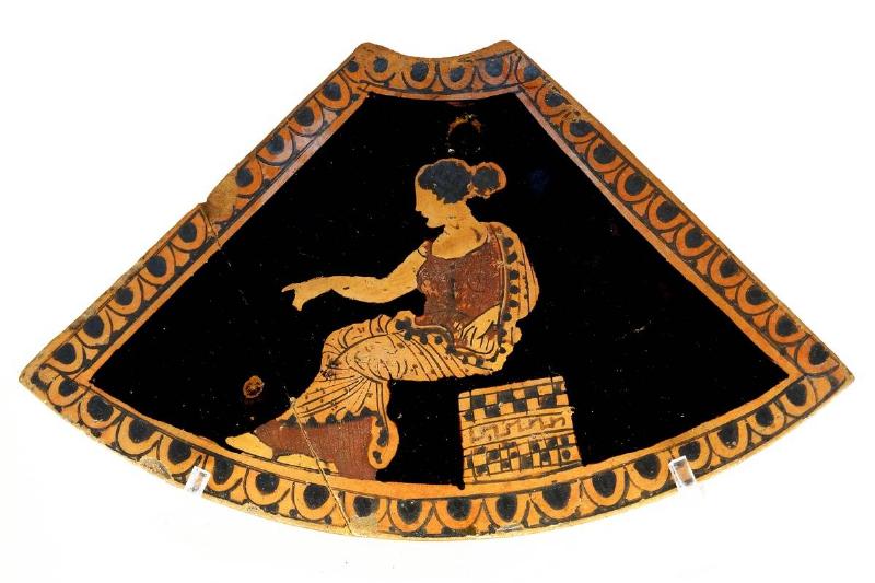 A lepaste, or toilet box, is decorated with a women sitting on a box.