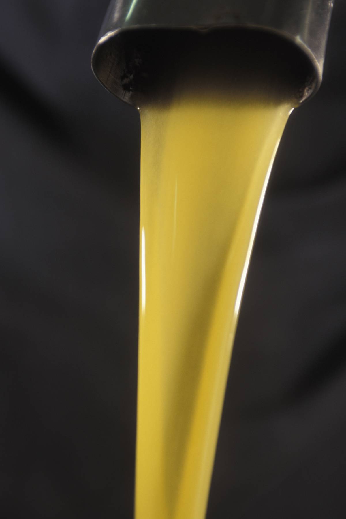 Olive oil pours from a spout.