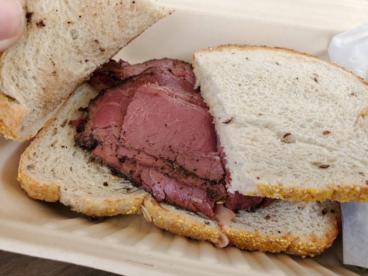 Pastrami sits on slices of white bread.