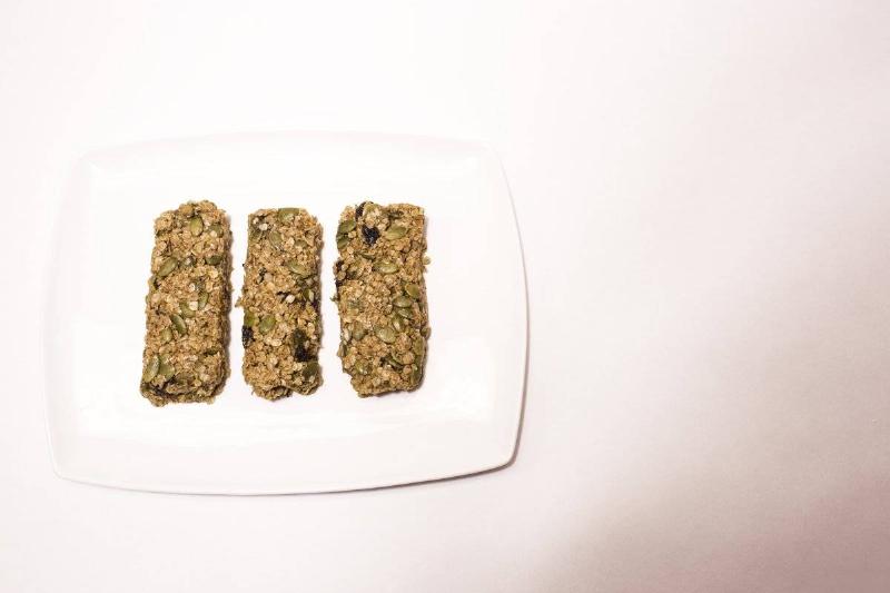 Three cereal bars sit on a plate.