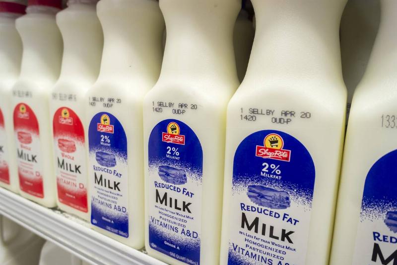 low-fat milk - 526662210 Reduced fat milk cartons are stacked on a grocery store shelf.