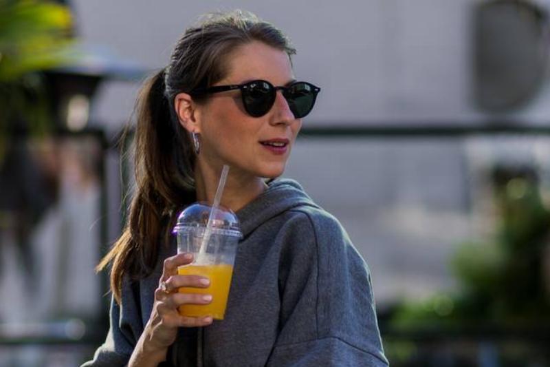 orange juice-596248526 A woman drinks orange juice.