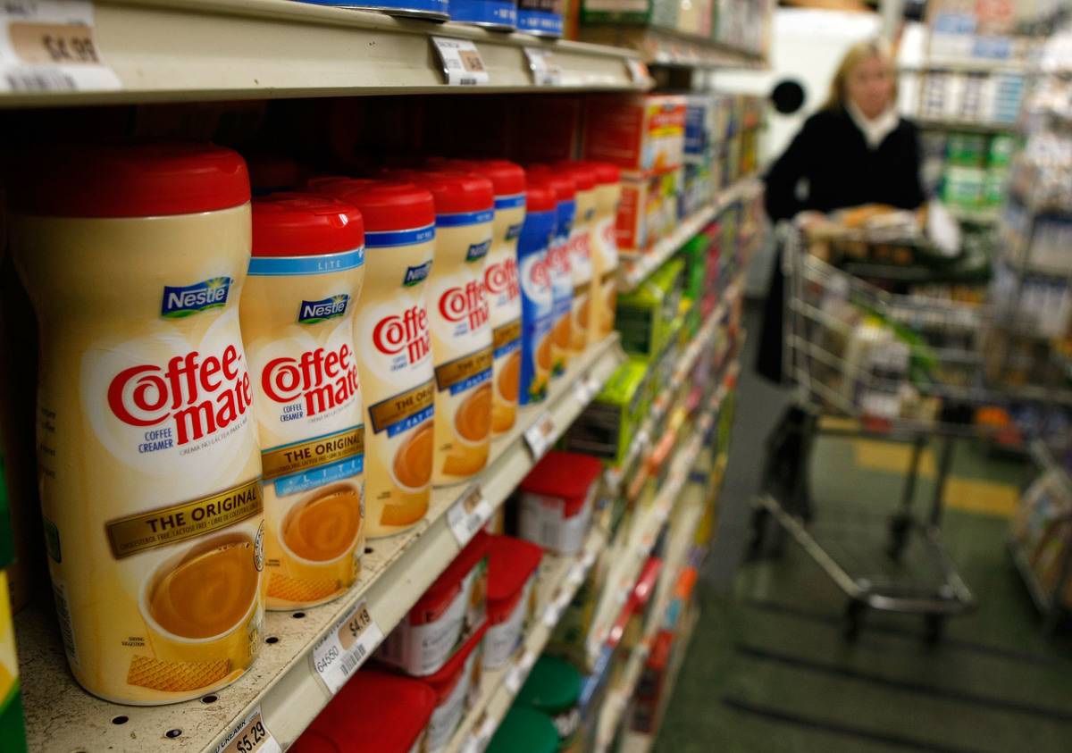 Containers of coffee cream sit on a grocery store.