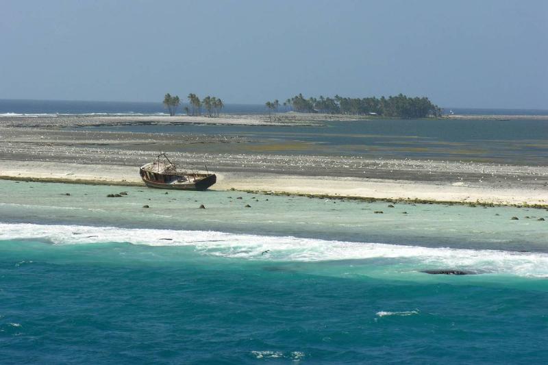 An abandoned boat sits on the shore of Clipperton Island.