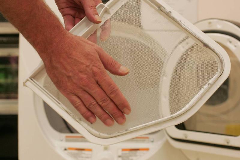GettyImages-165231473 cleaning out dryer lint person cleaning out dryer lint