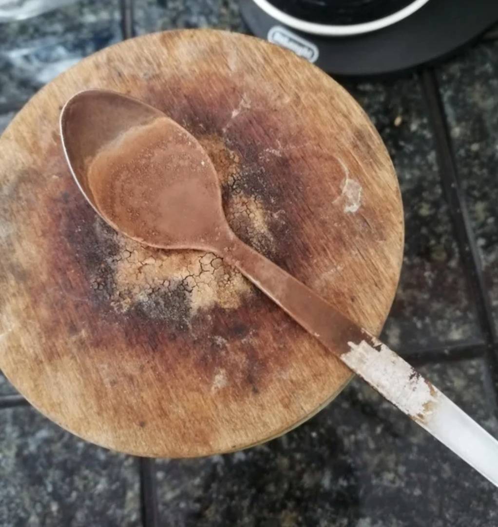 spoon so caked with cake that it looks very rusted 