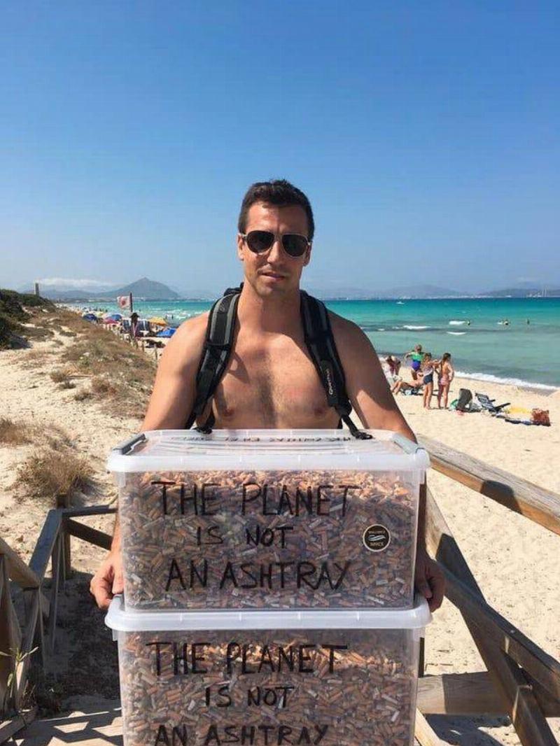 man collected cigarette butts at beach