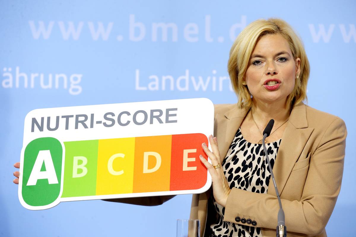 A woman holds up a score card that rates a food's nutritional value.