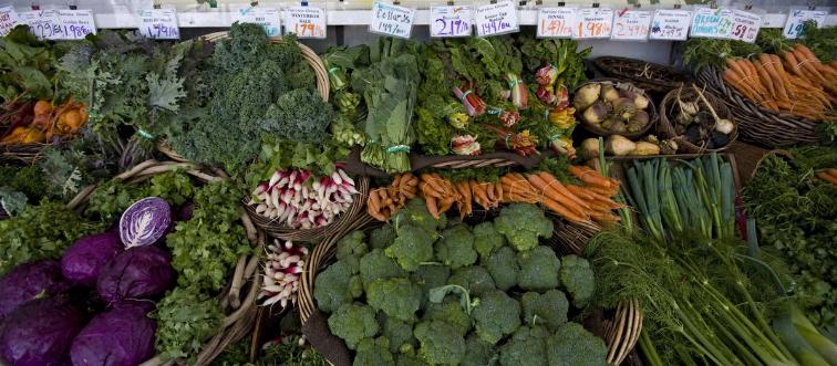 Piles of vegetables are offered for sale.
