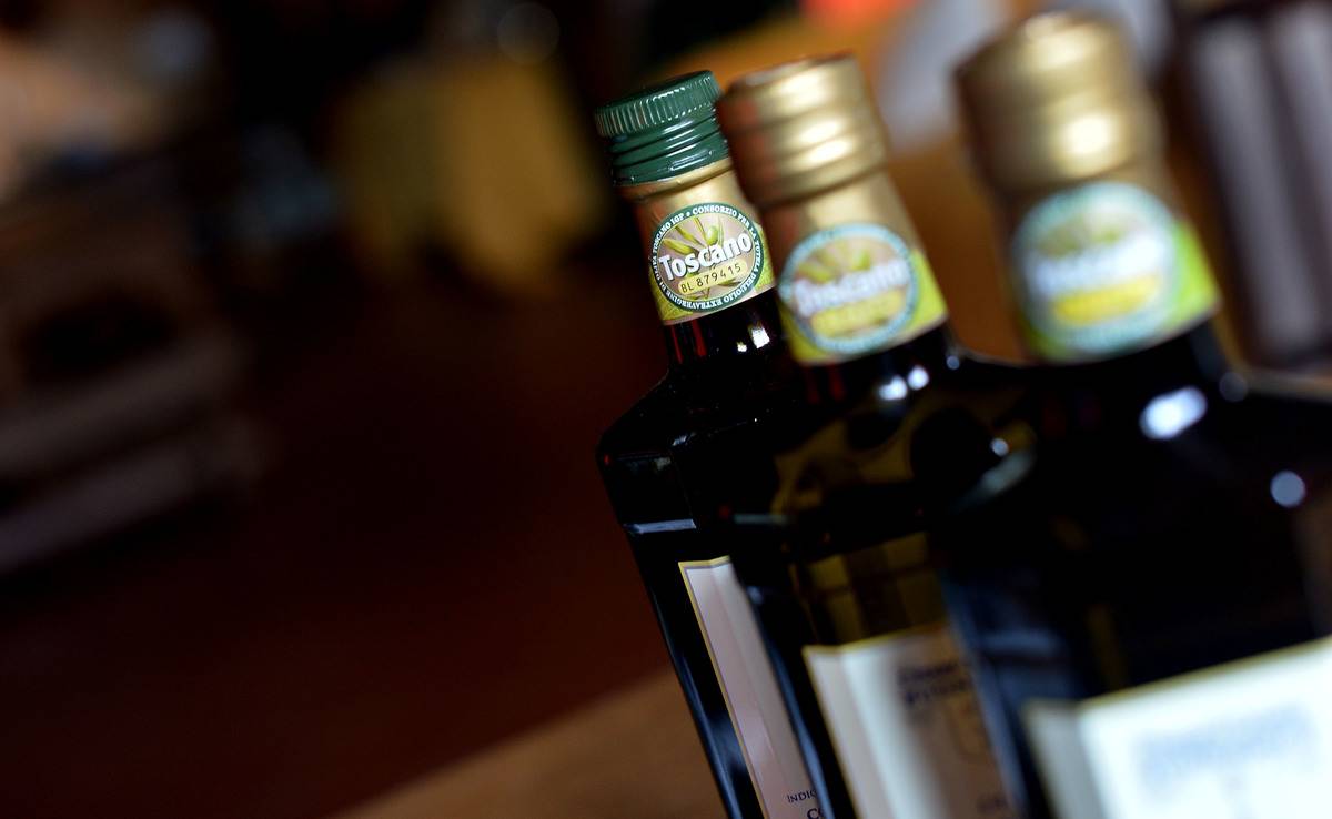 Bottles of olive oil stand in a line.