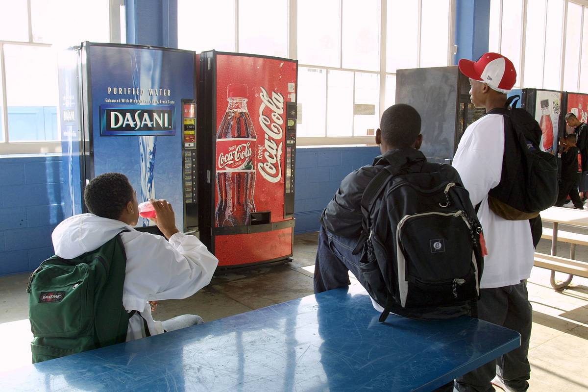 Students buy drinks from vending machines.