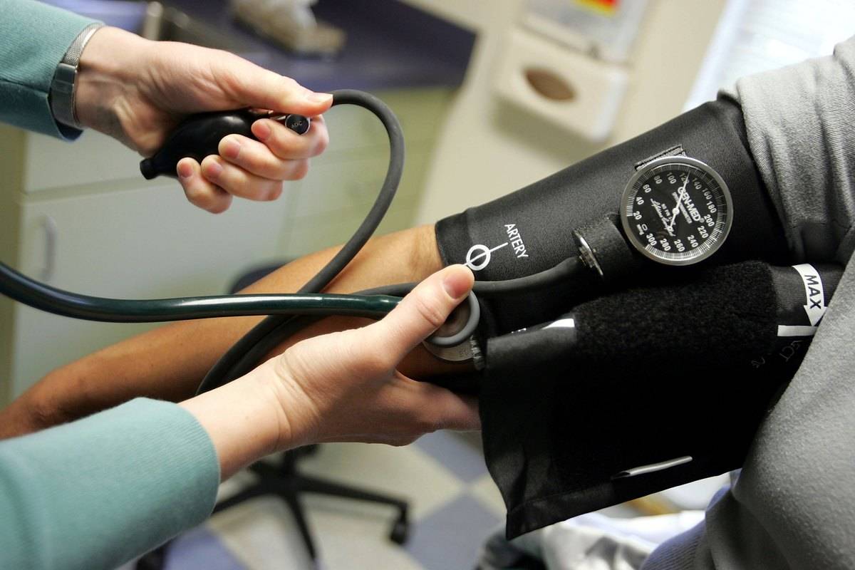 A doctor measures a patient's blood pressure.