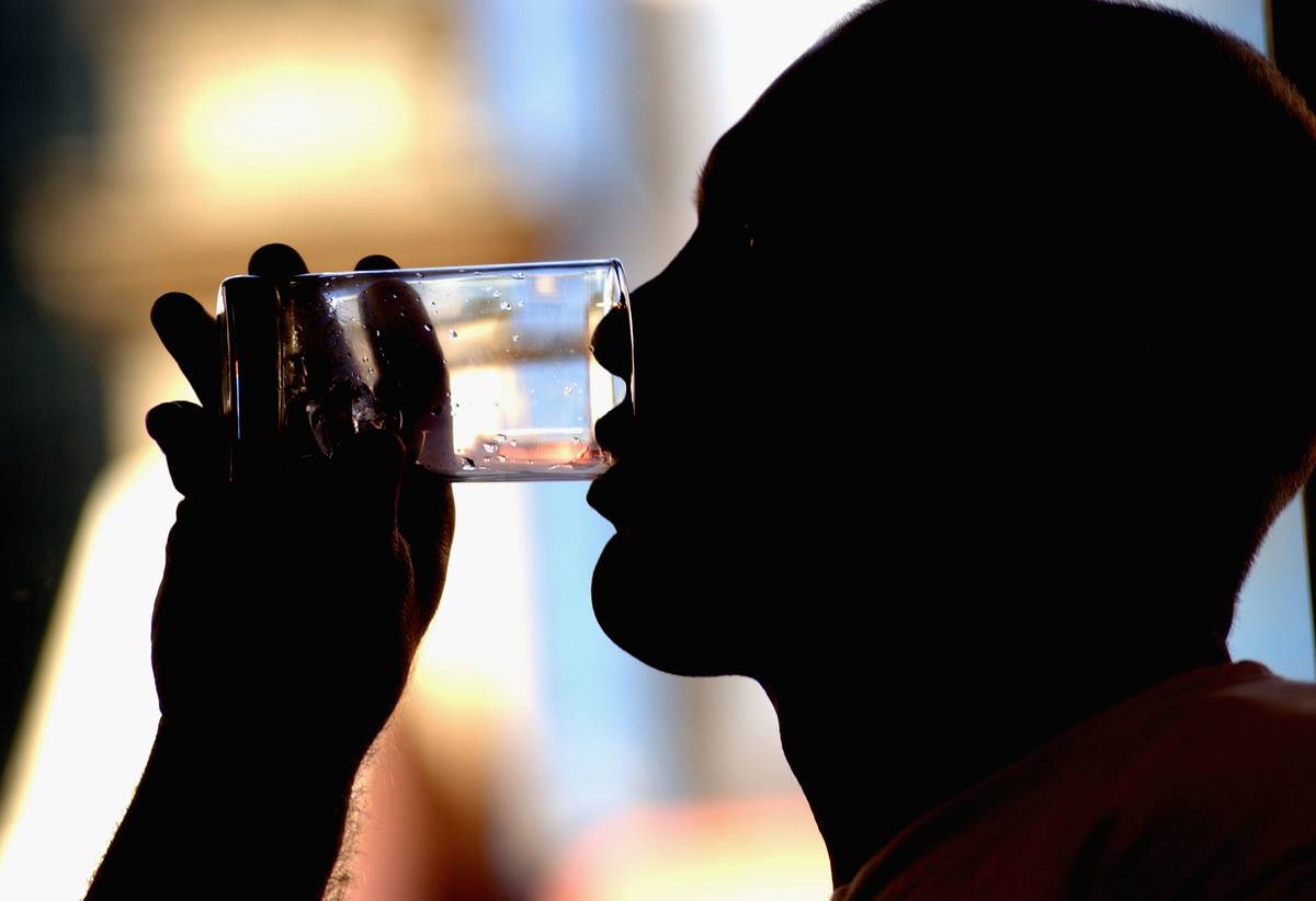 A man drinks from a glass.