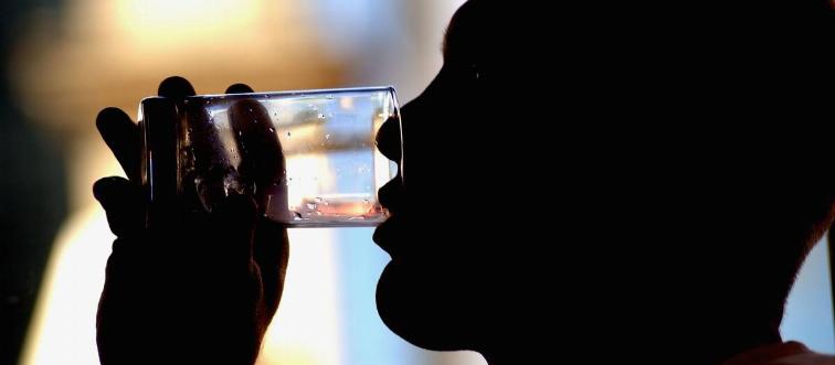 A man drinks from a glass.