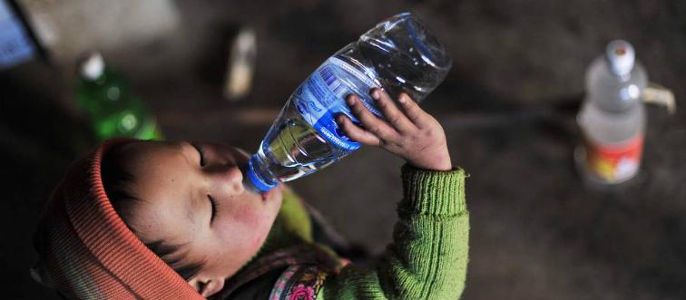 A boy drinks a water bottle.