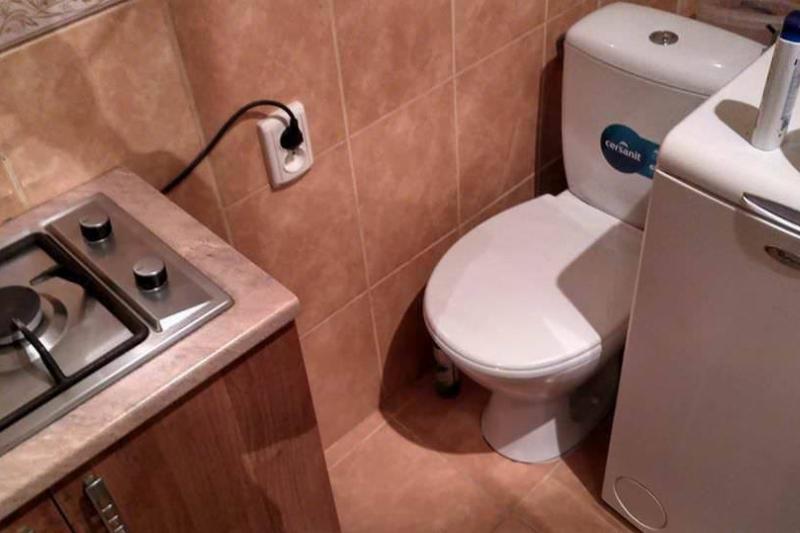 toilet in kitchen toilet right next to stove