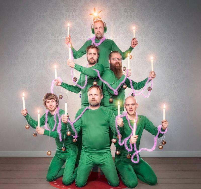 tree group of men in green holding candles to look like a shape of a christmas tree