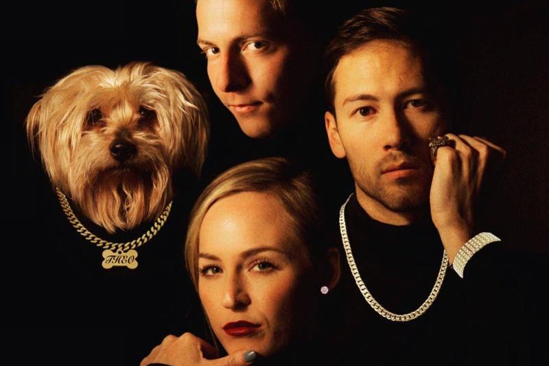 chains three people in black wearing chains and dog wearing a chain