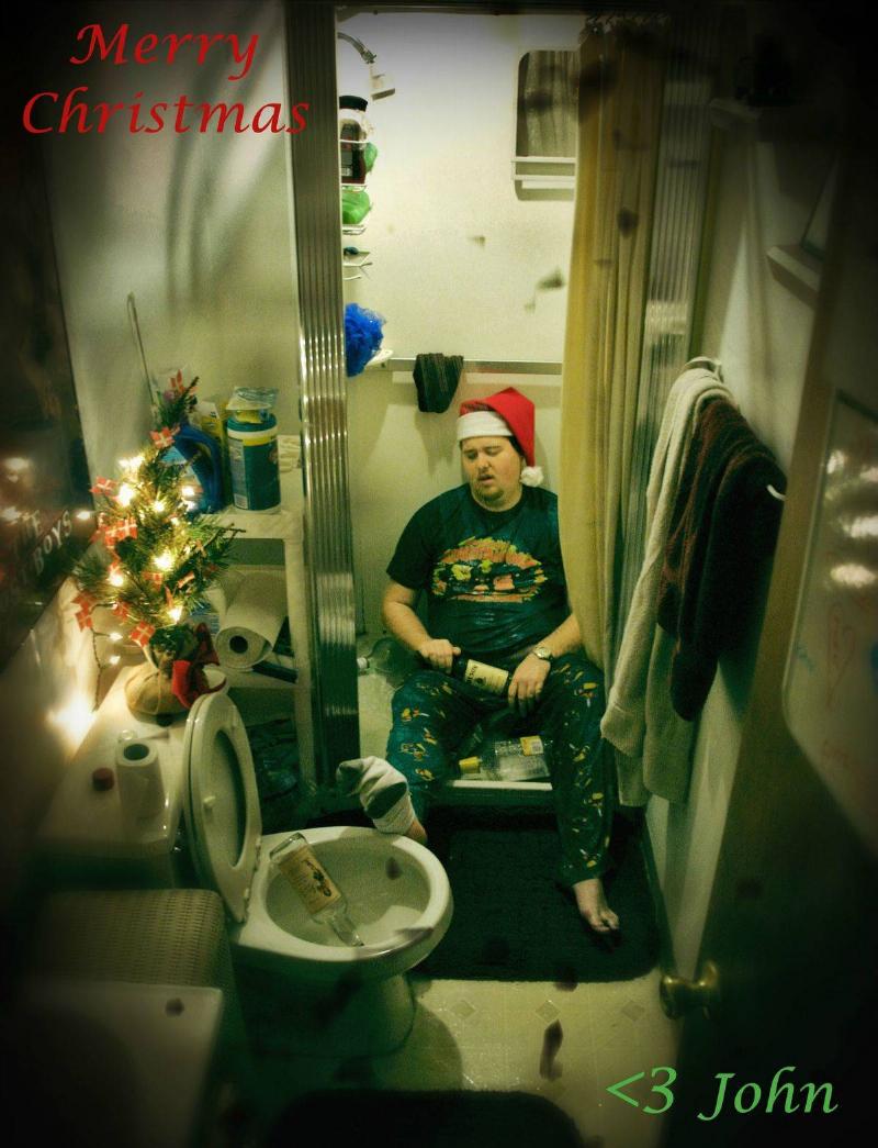 passed out man in santa hat passed out in bathroom with liquor bottles everywhere and script: Merry Christmas <3 John