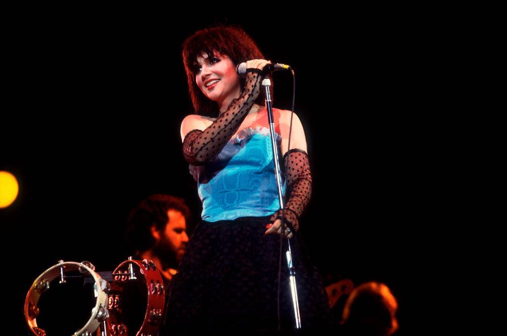 Linda Ronstadt wearing a blue top and fingerless gloves