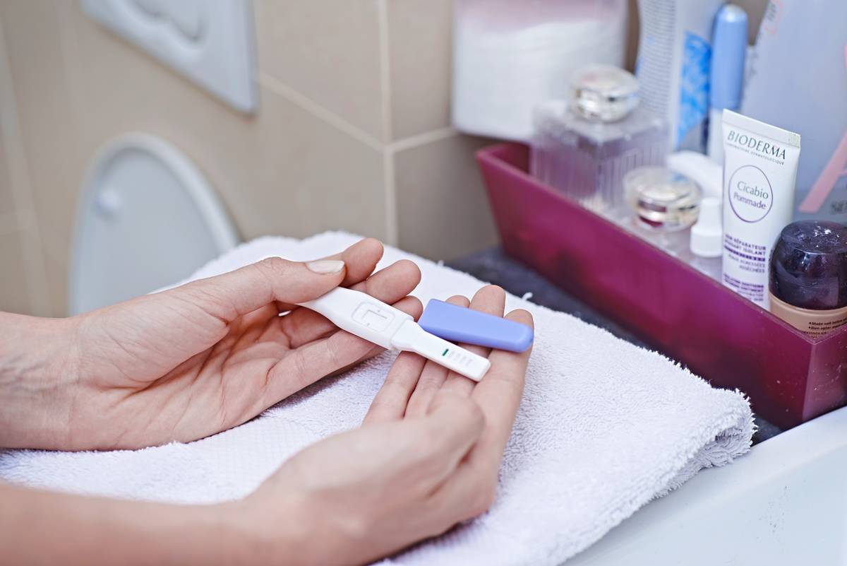 A woman holds a pregnancy test.
