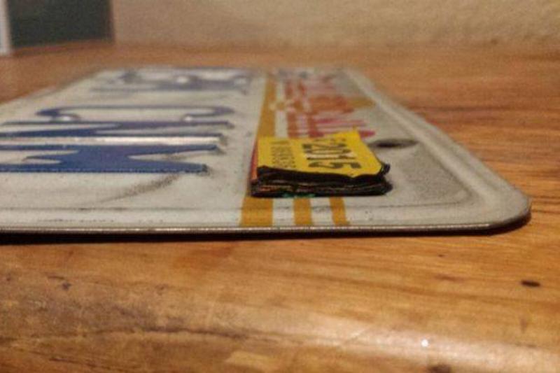half-inch-tall pile of license plate stickers on license plate