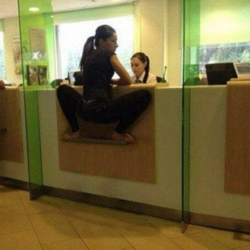 someone standing on the side of the teller's desk at the bank